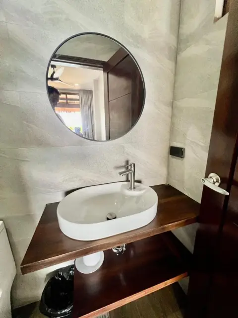 Round mirror and vessel basin in a room bathroom