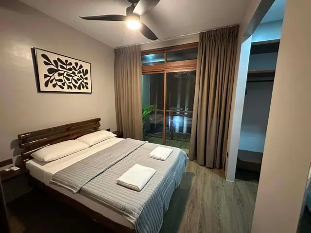 Double room with wooden bed and garden-facing windows